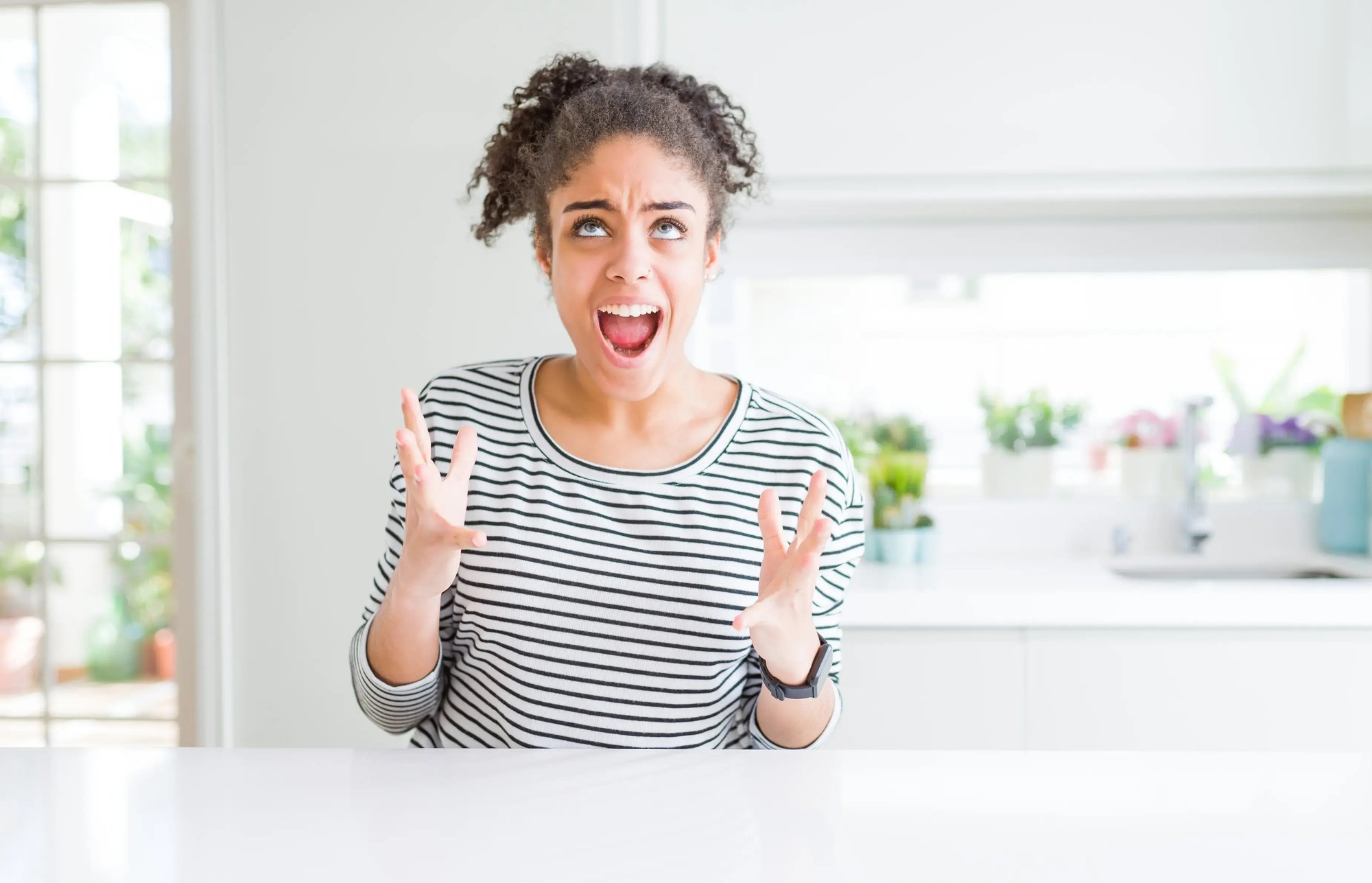 beautiful woman surprised by bug in kitchen screaming