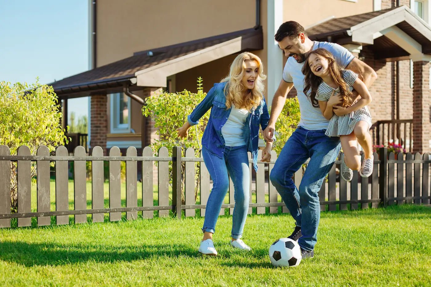 family playing soccer on a nice lawn - ss