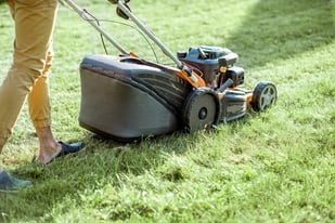 gardener-cutting-grass-with-lawn-mower-