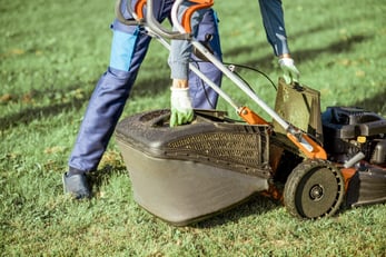 gardener-working-with-lawn-mower-on-the-backyard-